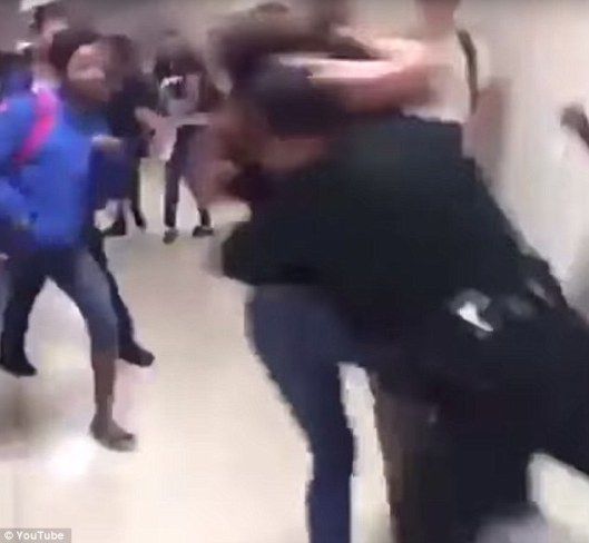 The guard is seen jumping into the frame and tackling the two girls to the ground, School Security Guard